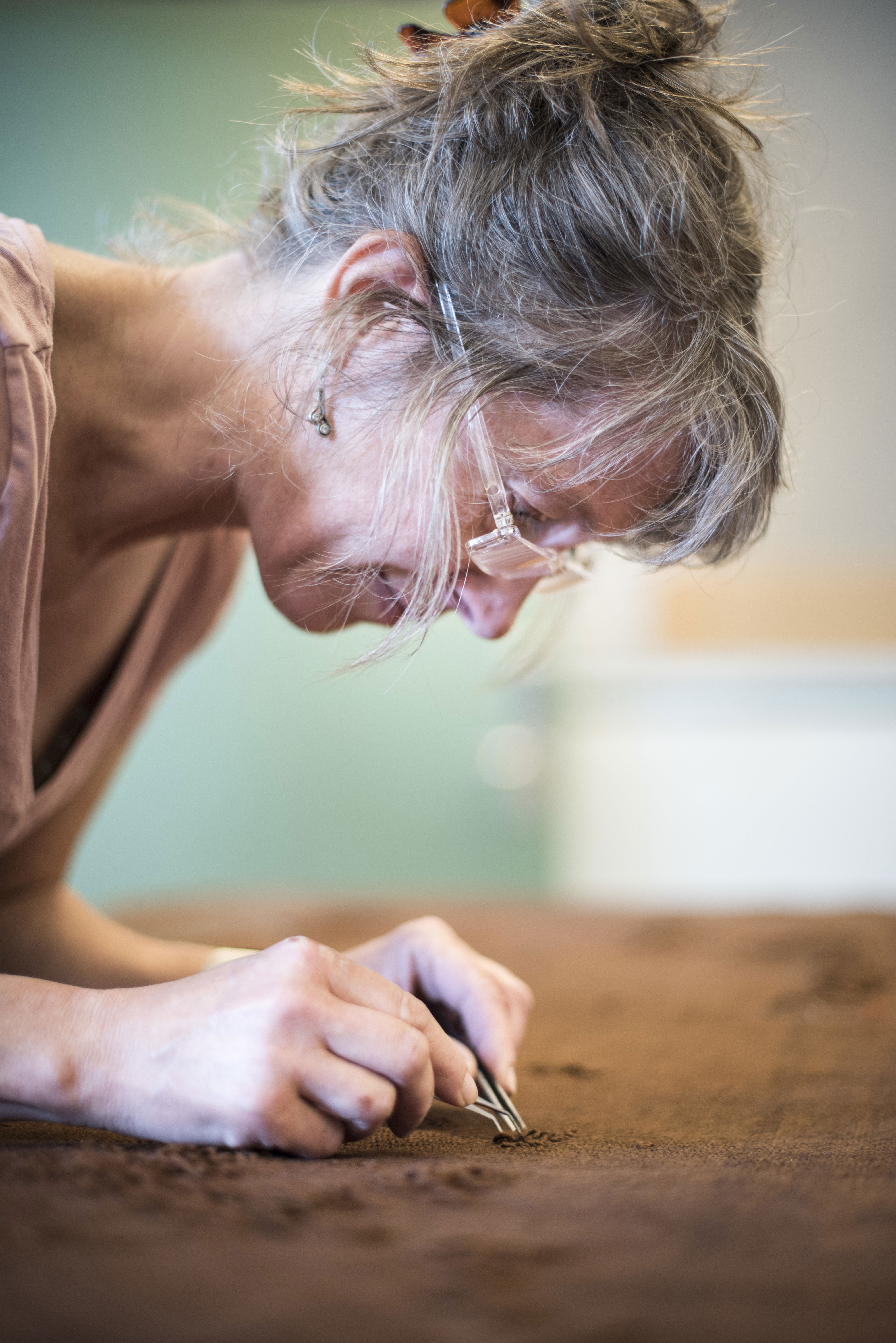 Konservatoren arbejder med tekstilet fra Auningkvinden