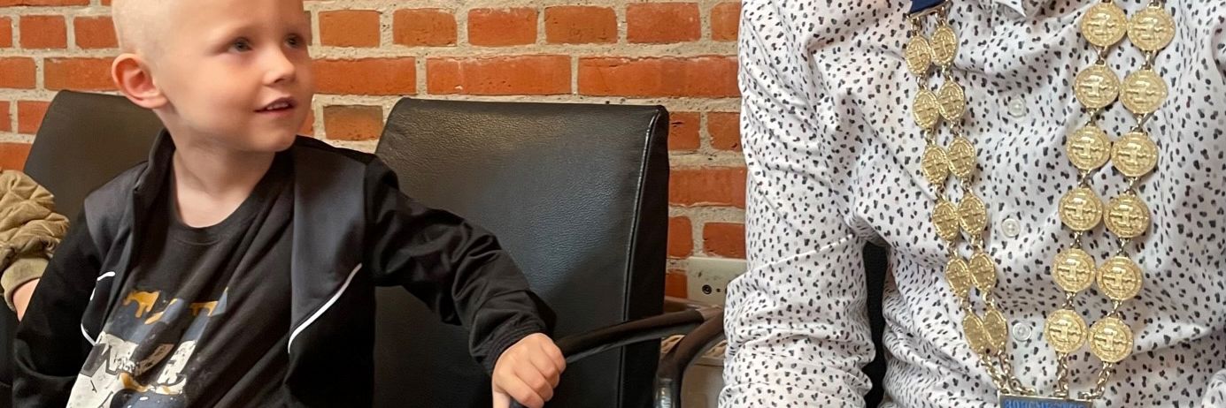 Dreng og borgmesteren sidder ved siden af hinanden