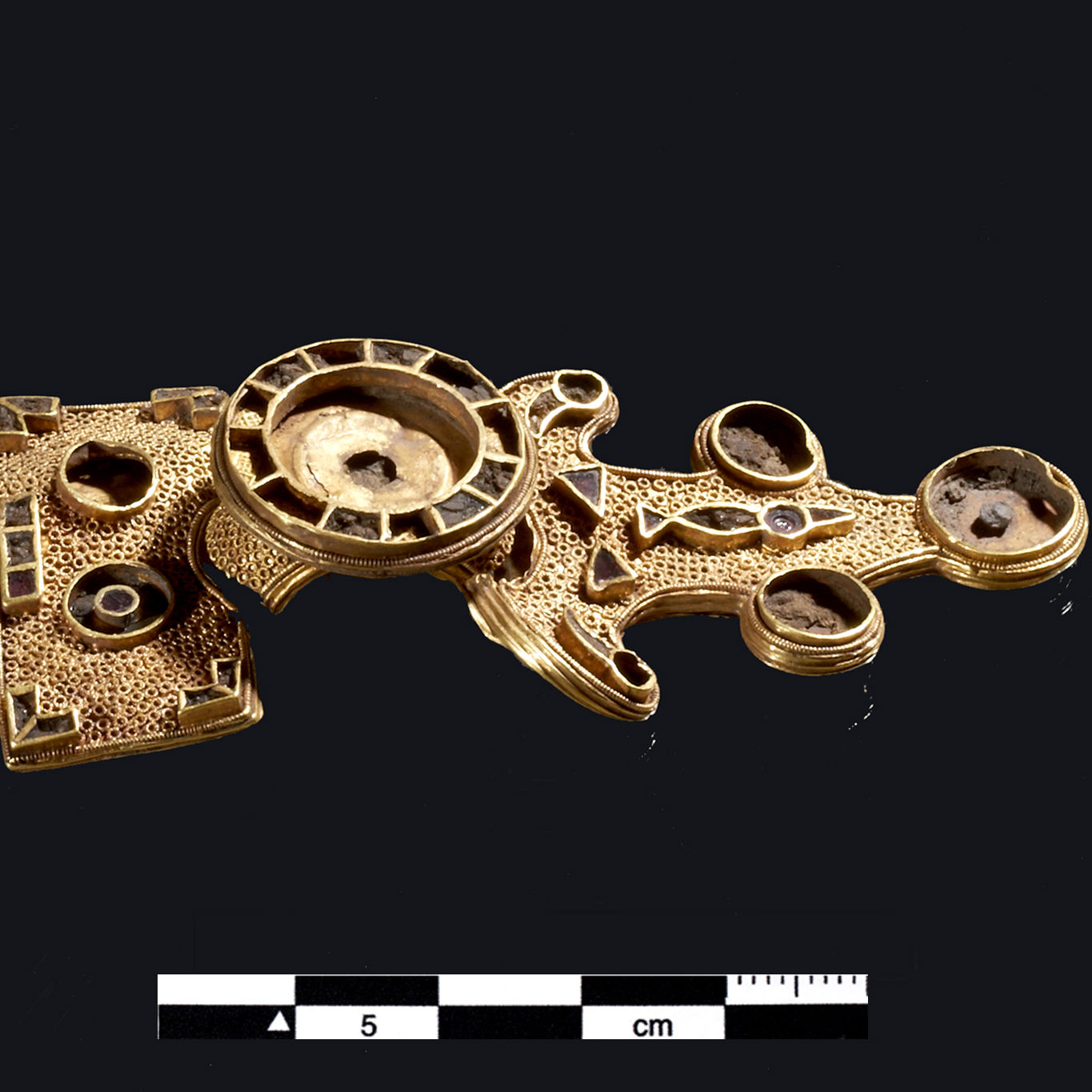 8 cm lang fibula fremstillet i guldblik med en kerne af ler fra Kirkemosegård