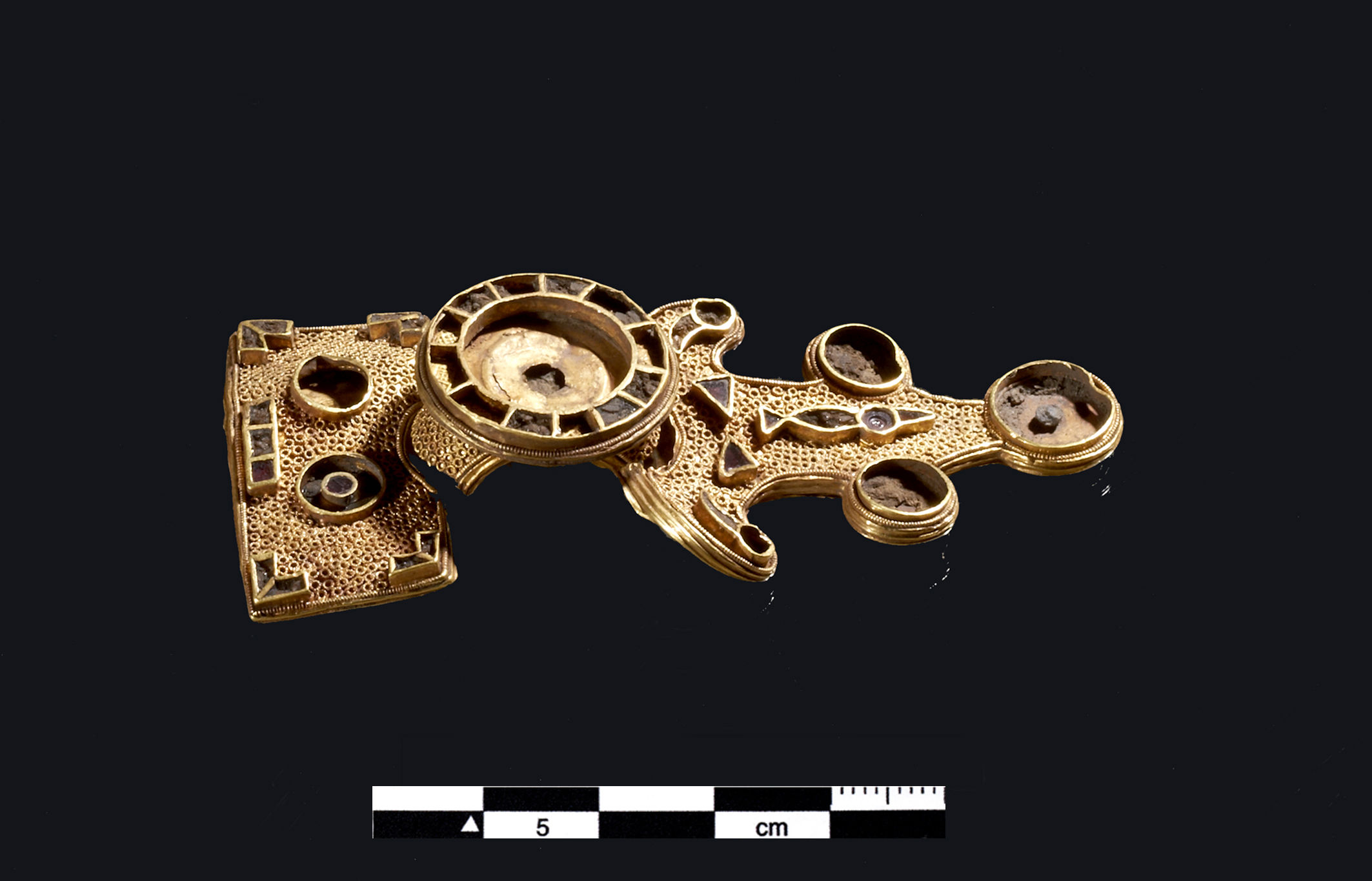 8 cm lang fibula fremstillet i guldblik med en kerne af ler fra Kirkemosegård