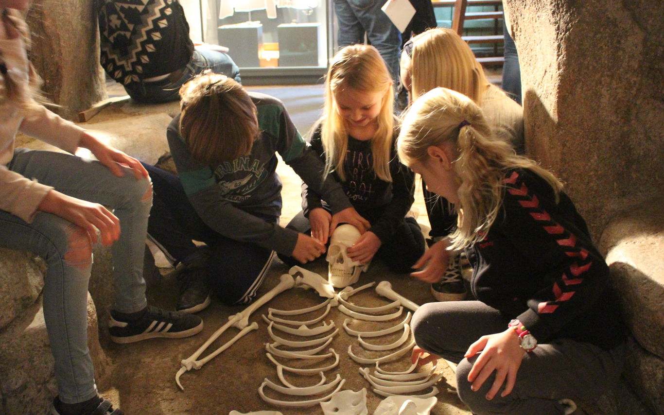 Børn sidder omkring et skelet i museets udstilling i Grenaa