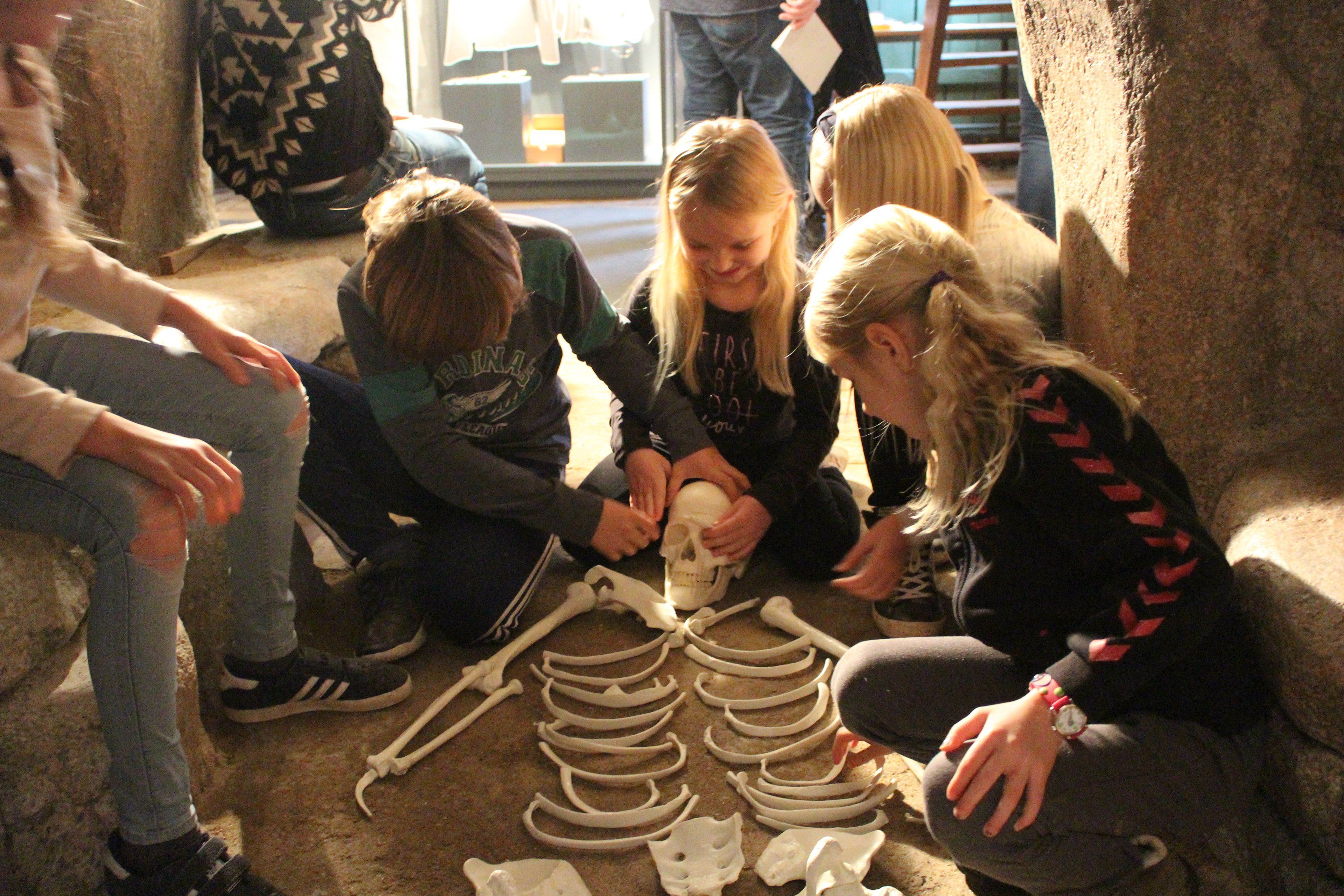 Børn sidder omkring et skelet i museets udstilling i Grenaa