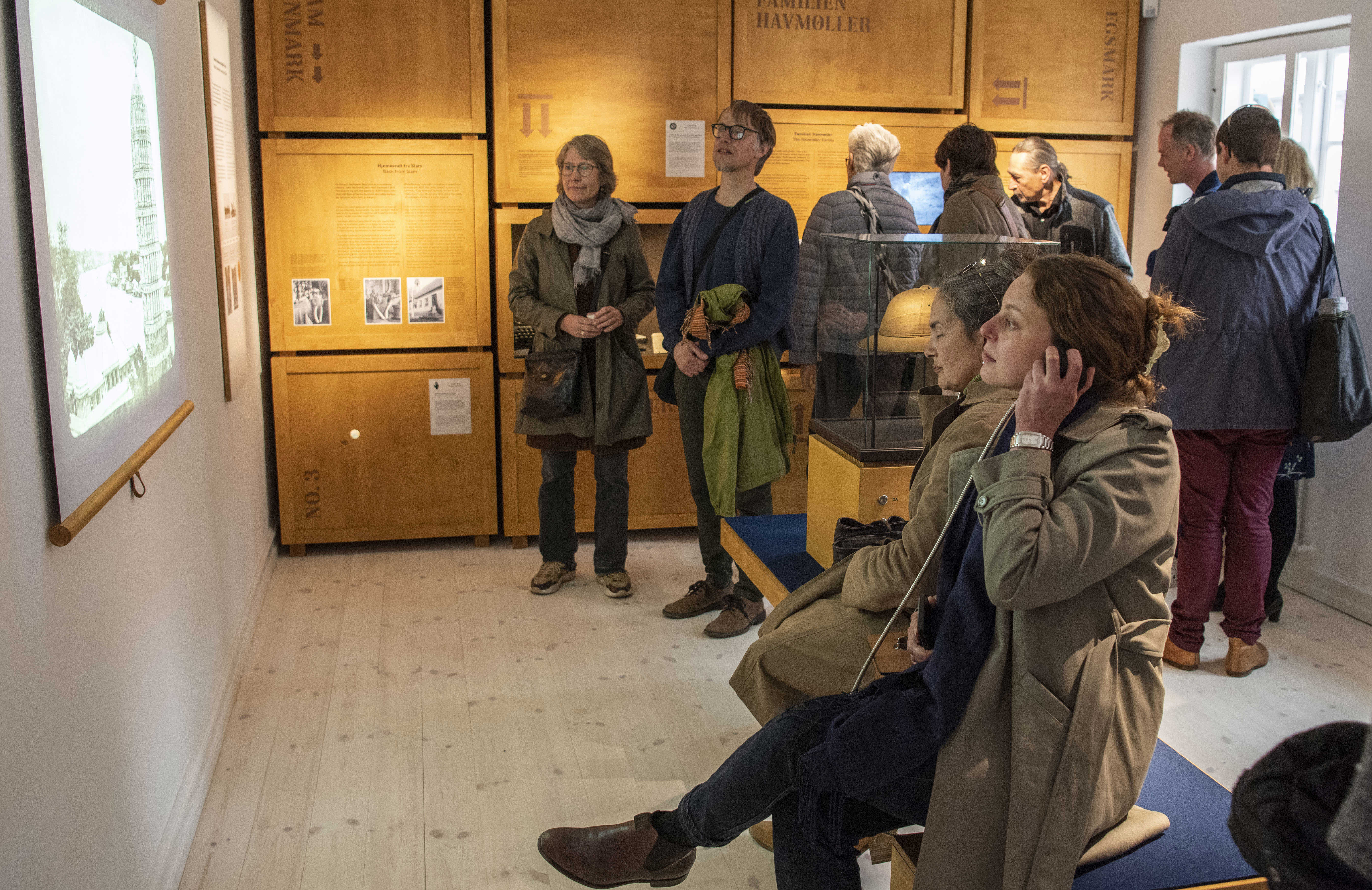 Gæster ser og lytter i udstillingen Skatkammer Siam i Ebeltoft